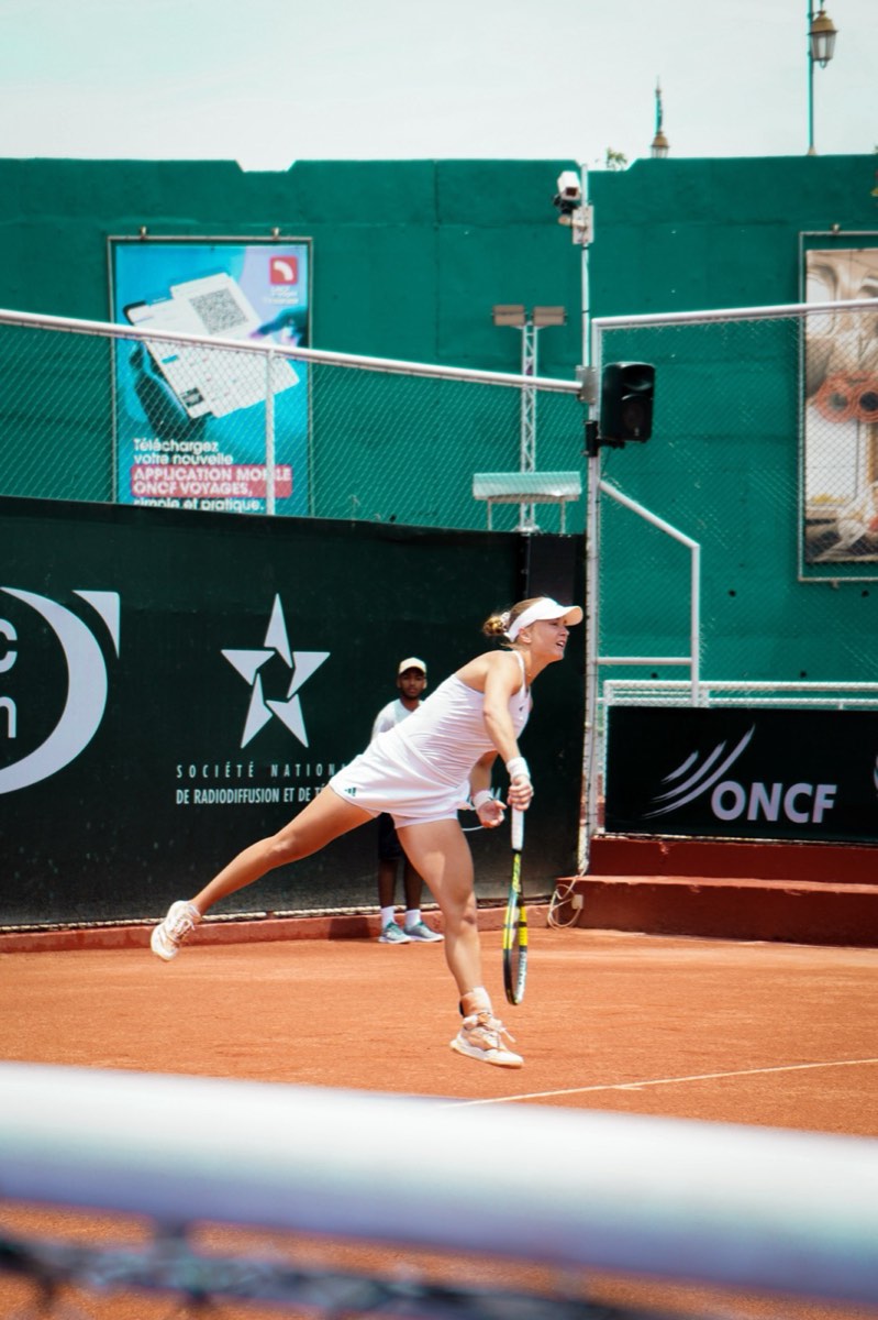 Tennis player serving on clay court